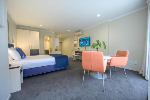 a hotel room with a bed and a table and chairs at U Residence Hotel in Wellington