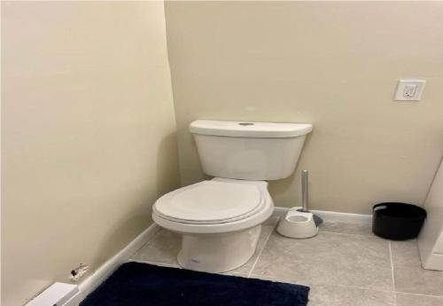 a bathroom with a white toilet and a blue rug at Home Made in Shawnee