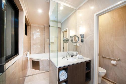 a bathroom with a sink and a shower and a toilet at Burke and Wills Hotel Toowoomba in Toowoomba