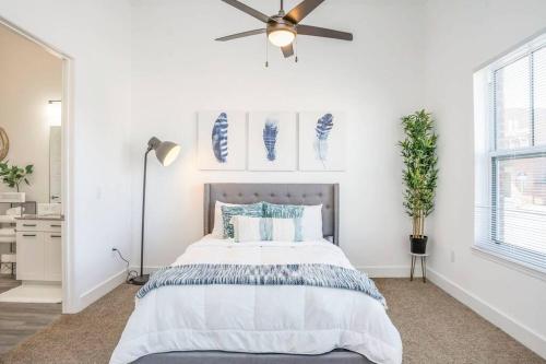 a white bedroom with a bed and a ceiling fan at Cozy Atlanta Apartment in Atlanta