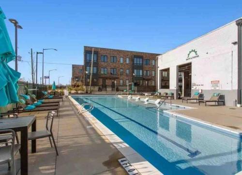 a pool at a hotel with tables and chairs at Cozy Atlanta Apartment in Atlanta
