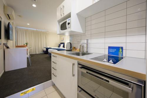 a kitchen with a sink and a stove top oven at U Residence Hotel in Wellington