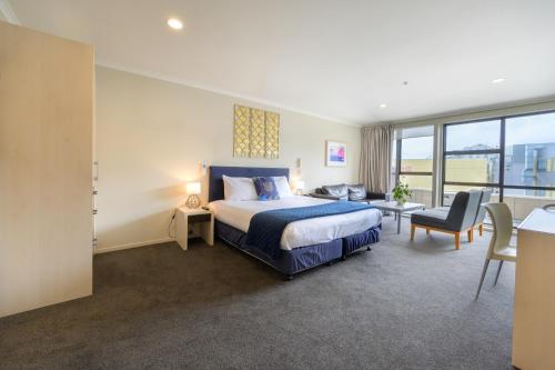 a bedroom with a king sized bed and a living room at U Residence Hotel in Wellington