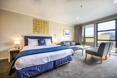 a hotel room with a bed and a chair at U Residence Hotel in Wellington