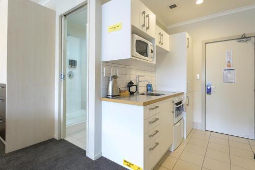a kitchen with a sink and a microwave at U Residence Hotel in Wellington