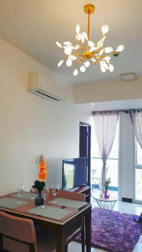 a dining room with a table and a chandelier at Mactan Newtown - 1BR Stunning Ocean View and City View in Mactan