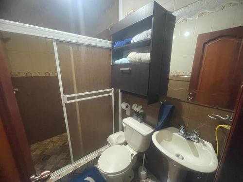a bathroom with a toilet and a sink and a shower at Hermoso y cómodo loft con vista a los nevados in Riobamba