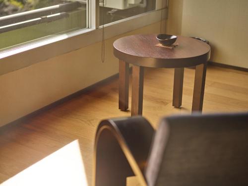 a small table with a bowl on it next to a window at Ito Yukitei in Ito