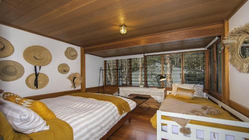 a bedroom with a bed and a large window at Oceanic Coastal Lodge Pearl Beach in Pearl Beach