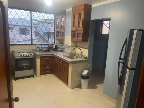 a kitchen with a sink and a stove at Hermosos Departamentos con Vista a los Nevados in Riobamba