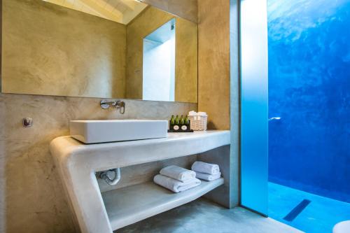 a bathroom with a sink and a mirror at Alekos Beach Houses-Profilio's Villas in Lixouri