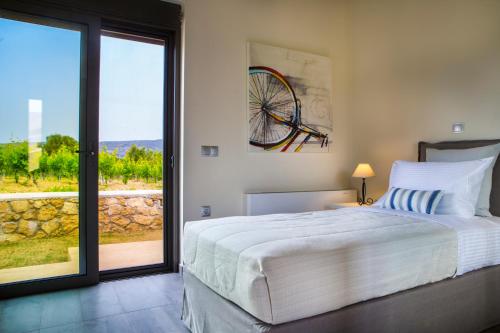 a bedroom with a large bed and a large window at Alekos Beach Houses-Profilio's Villas in Lixouri