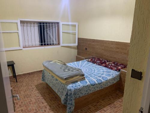 a small bedroom with a bed and a window at Torre del mar in Moulay Bousselham