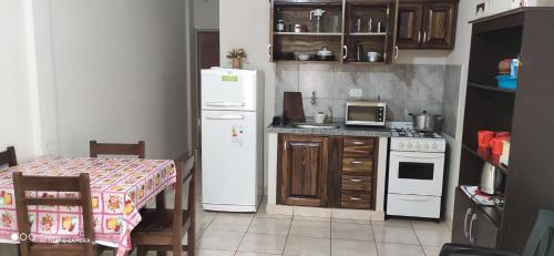 a small kitchen with a white refrigerator and a table at Edificio Cesar en Eldorado por día in Eldorado