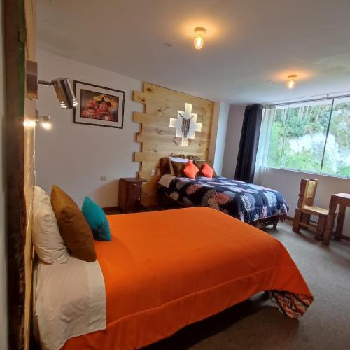 a bedroom with two beds and a window at CASA SAPANTIANA con vista al bosque, cerca a Sacsayhuaman in Cusco