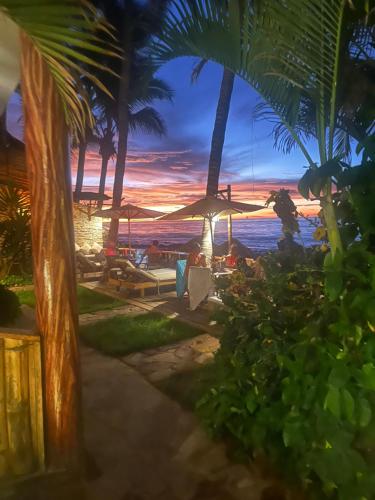 a view of a beach with palm trees and a sunset at Los Corales in Máncora