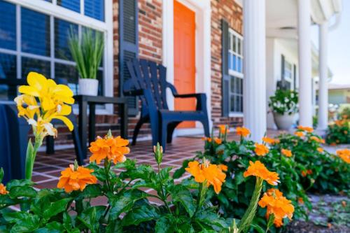 a porch with two chairs and orange flowers at 5027 Fairfield DR - Paradise Palms home in Fort Myers