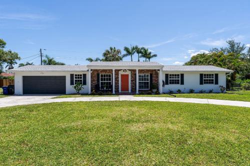 a house with a red door and a yard at 5027 Fairfield DR - Paradise Palms home in Fort Myers