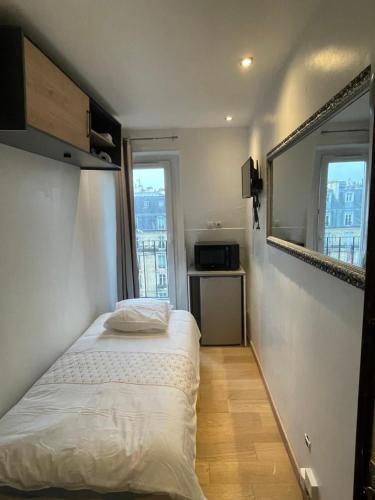 une petite chambre avec un lit et une fenêtre dans l'établissement Douchedodo, à Paris