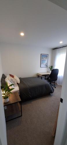 a bedroom with a bed and a desk and a chair at Inner City 2 Bedroom Unit in Hamilton