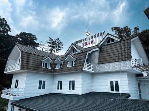 a white building with a sign on top of it at Cherry Luxury Hotel in Da Lat