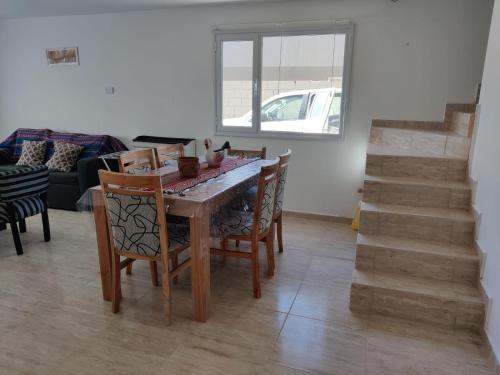 een eetkamer met een tafel en stoelen en een trap bij Duplex Bosch in Neuquén