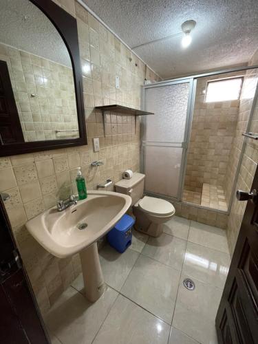 a bathroom with a sink and a toilet at Departamento en el centro de la ciudad de Baños con netflix, wifi, garage gratuito y una excelente vista in Baños