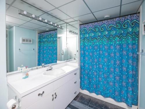 baño con lavabo y cortina de ducha azul en 1B/1B condo with Ocean views, Resort style, Free WIFI, Few steps to the Beach!! en Wildwood Crest