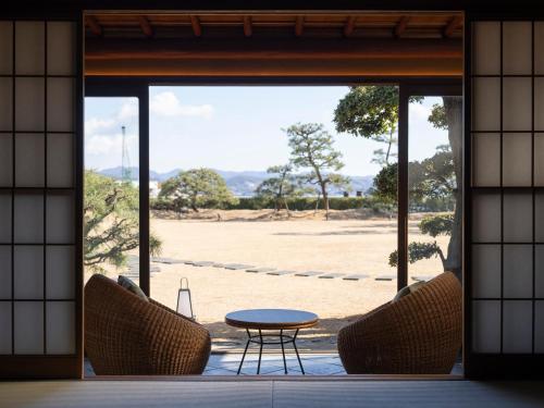 Elle offre une vue sur une terrasse avec une table et des chaises. dans l'établissement Ryokan Onomichi Nishiyama, à Onomichi