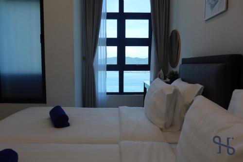 a white bed in a room with a window at Homesuite' Home at Jesselton Quay in Kota Kinabalu