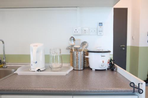 a kitchen counter with a blender and other appliances on it at Homesuite' Home at Jesselton Quay in Kota Kinabalu