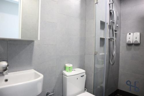 a bathroom with a toilet and a sink and a shower at Homesuite' Home at Jesselton Quay in Kota Kinabalu