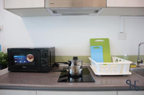 a microwave sitting on top of a stove in a kitchen at Homesuite' Home at Jesselton Quay in Kota Kinabalu