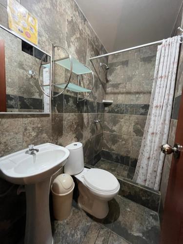 La salle de bains est pourvue de toilettes, d'un lavabo et d'une douche. dans l'établissement Hostal Inkanto Taruma, à Tarma