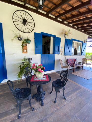 a patio with a table and chairs and blue cabinets at Jardim D’Jully in Santa Terezinha de Itaipu