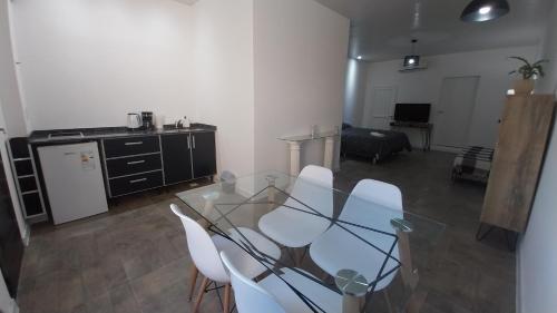 a living room with a glass table and white chairs at Adrogue Apart Airport Shuttle 24hs in Burzaco
