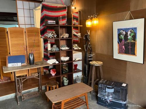 una habitación con una mesa y un estante con zapatos en 下田市旧南豆, en Shimoda