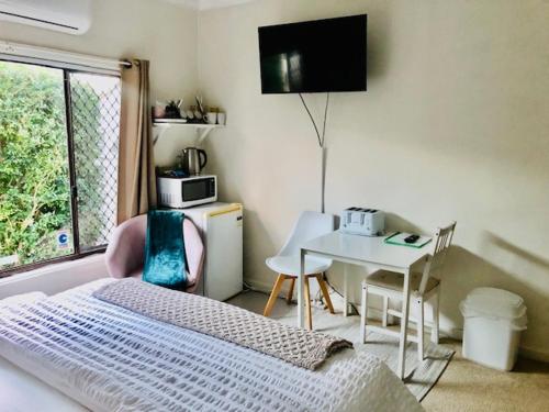 een slaapkamer met een bed, een tafel en een televisie bij Hotel Style Monterey Guest Studio near Hospitals, Beach and Airport in Sydney