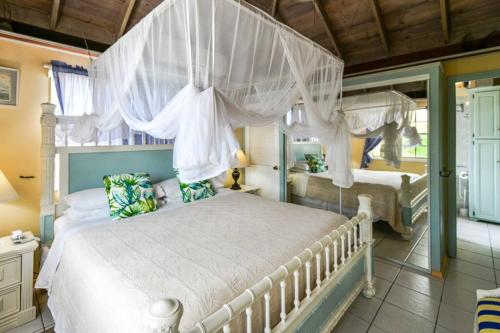 a bedroom with a white bed with a canopy at Little Rock Cottage in Cobbs Cross