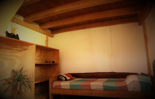 a room with a bed in a room with wooden ceilings at Colibrí Apart in El Soberbio