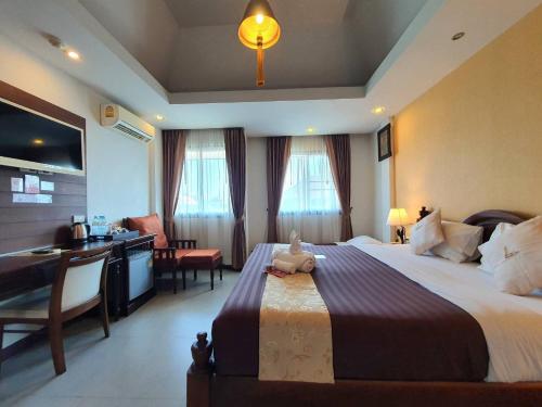 ein Hotelzimmer mit einem Bett mit einem Teddybär darauf in der Unterkunft Goldenbell Hotel Chiangmai in Chiang Mai