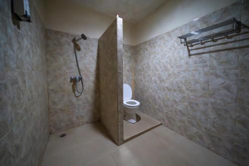 a bathroom with a shower and a toilet in it at Family Garden Homestay in Senggigi