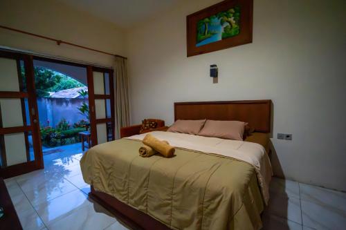 a bedroom with a bed with a teddy bear on it at Family Garden Homestay in Senggigi