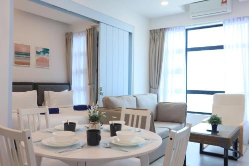 a kitchen and living room with a table and chairs at Homesuite' Home at Jesselton Quay in Kota Kinabalu