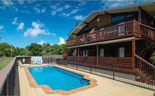 a house with a swimming pool in front of it at Marlin Villa - Hervey Bay in Urangan