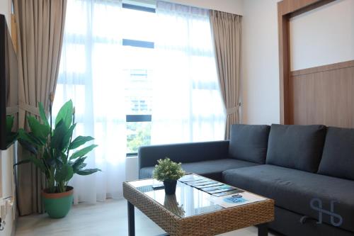 a living room with a blue couch and a table at Homesuite' Home at Jesselton Quay in Kota Kinabalu