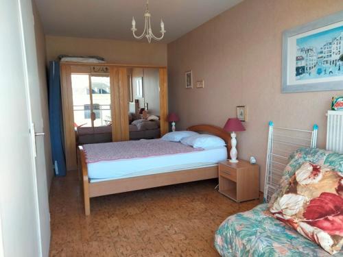 une petite chambre avec un lit et un canapé dans l'établissement Appartement Type 2 avec balcon et parking - Les Sables-d'Olonne - FR-1-331-216, à Les Sables-dʼOlonne