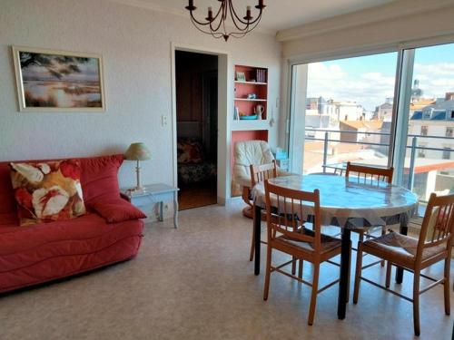 un salon avec un canapé rouge et une table dans l'établissement Appartement Type 2 avec balcon et parking - Les Sables-d'Olonne - FR-1-331-216, à Les Sables-dʼOlonne