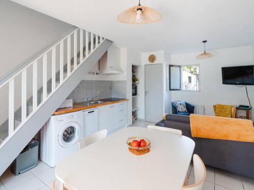 Il comprend une cuisine et un salon avec une table blanche et un canapé. dans l'établissement Duplex à Saint-Pierre-La-Mer - Parking, 2 Chambres, Terrasse - FR-1-409A-24, à Fleury