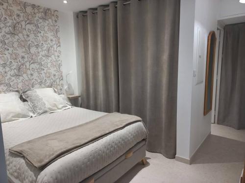 une chambre avec un lit et une fenêtre avec des rideaux dans l'établissement T1 climatisé avec jardin, piscine, tennis, à 750m de la plage - Parc Des Oliviers - FR-1-610-85, à Bormes-les-Mimosas